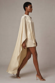 Satin Asymmetrical Cape Dress — Cream — AI-generated studio left-side walking view